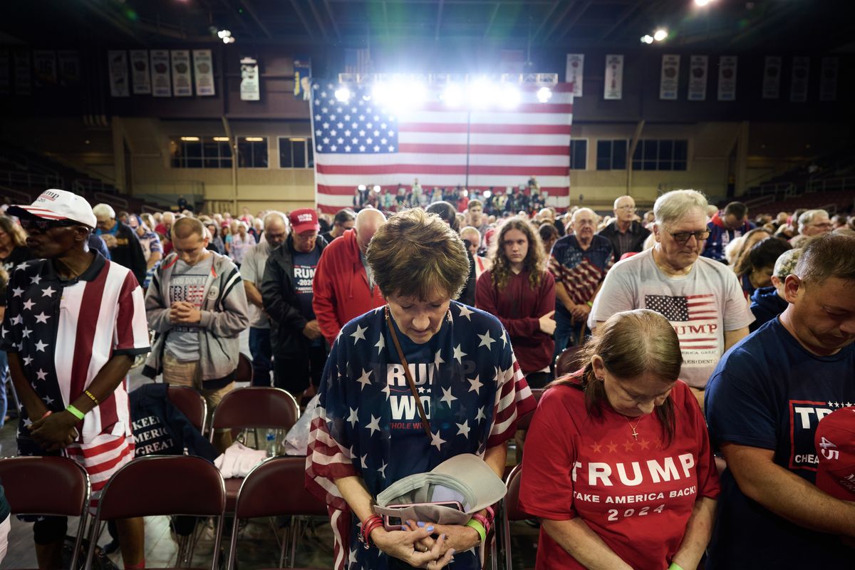 Supporters of Donald Trump are shown praying during a rally in Erie, Pennsylvania, in July 2023.   (Dustin Franz/For The Washington Post)