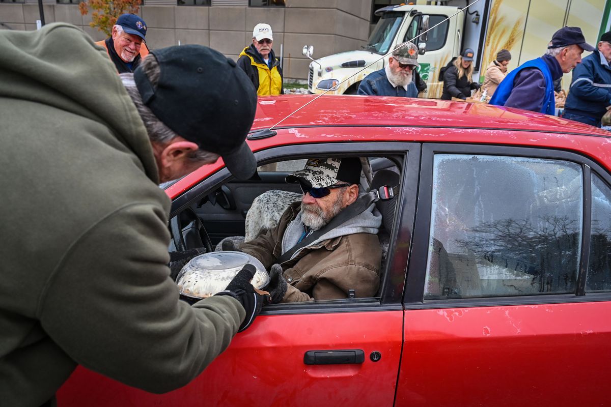 Ralph Moorhead, a volunteers from the Knights of Columbus, delivers a cream pie to Army veteran Vern Dixon during the Veterans Day Mann-Grandstaff VA Medical Center Second Harvest Inland Northwest free food drive-thru on Friday in Spokane.  (DAN PELLE/THE SPOKESMAN-REVIEW)