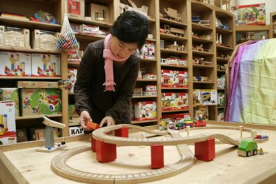 Ava Mar, 8, plays with a wooden train set at the Playstore in Palo Alto, Calif. Makers of handcrafted toys are concerned that strict new federal safety regulations could drive them out of business.  (Associated Press / The Spokesman-Review)