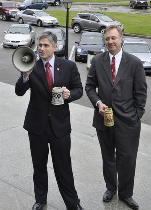 OLYMPIA -- Sens Mike Baumgartner and Doug Ericksen show off beer steins while addressing a crowd on the Capitol steps protesting a new tax on microbreweries. (Jim Camden)