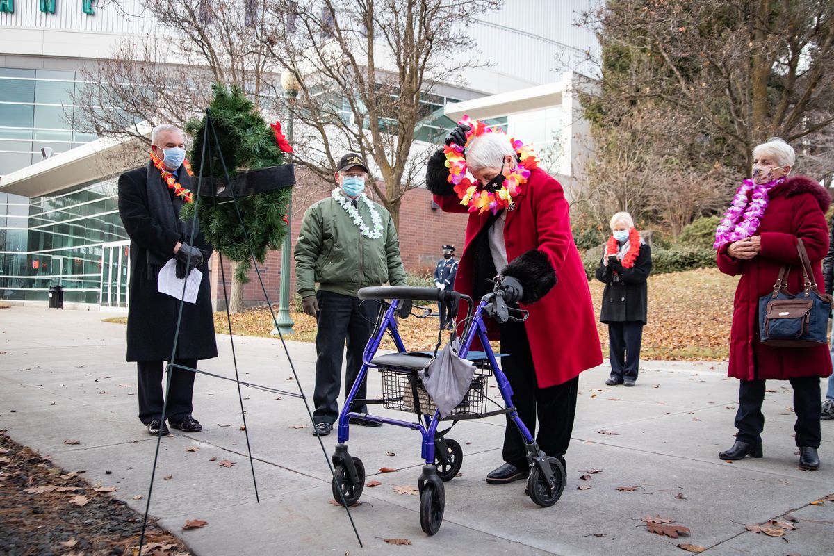Vina Mikkelsen, widow of former Navy radioman Denis Mikkelsen of the USS Virginia, places the first lei on the wreath Sunday, commemorating the Dec. 7, 1941, attack on Pearl Harbor at the Pearl Harbor monument outside of the Spokane Veterans Memorial Arena in Spokane. (Libby Kamrowski/ THE SPOKESMAN-REVIEW)