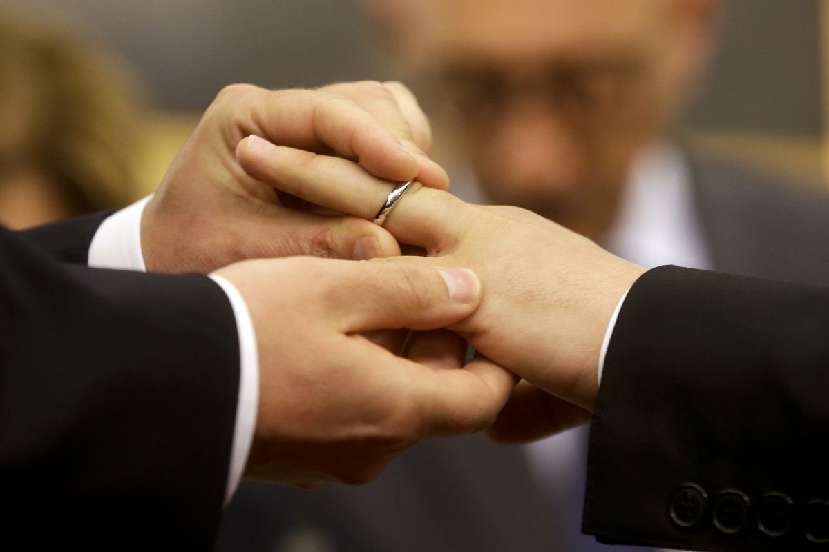 FILE - In this May 21, 2015 file photo, Mauro Cioffari, left, puts a wedding ring on his partner Davide Conti