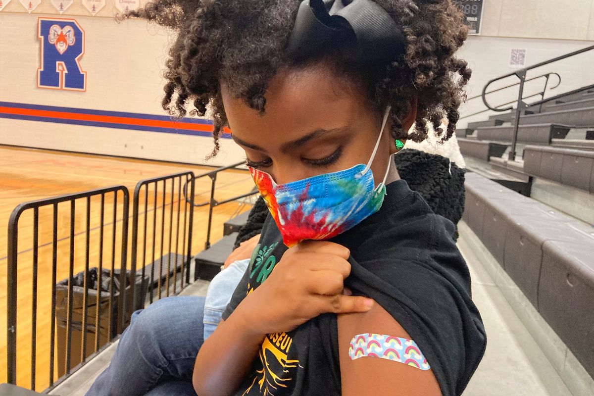 Solome Walker, 9, looks down at her bandage after getting her first Pfizer COVID-19 shot at a vaccination clinic for young students at Ramsey Middle School on Saturday in Louisville, Ky. Scientists say vaccinating kids helps prevent potentially dangerous variants from emerging.  (Laura Ungar)