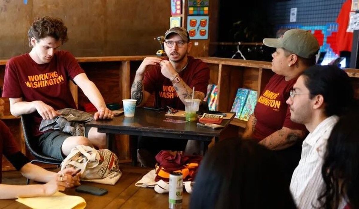 Charlie Capps, center, speaks in Seattle with other canvassers Tuesday from Working Washington about workers’ rights, particularly as they relate to immigration fears and issues surrounding the World Cup. (Seattle Times)