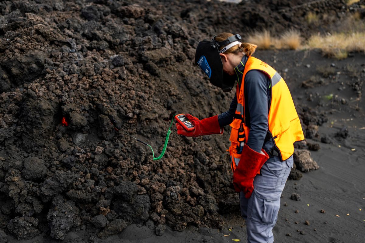 A scientist with the Canary Islands' volcanology institute, Involcan, measures the temperature of a lava flow on the Canary island of La Palma, Spain, Saturday, Oct. 30, 2021. Scientists from around the world flocking to an eastern Atlantic Ocean island are using an array of new technologies available to them in 2021 to scrutinize — from land, sea, air, and even space — a rare volcanic eruption. But despite technological and scientific leaps, predicting volcanic eruptions and, more crucially, how they end, remains a mystery.  (Emilio Morenatti)