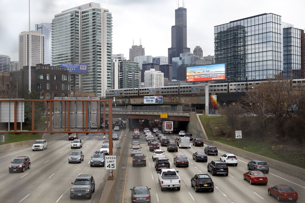 FILE - In this March 31, 2021,photo, traffic flows along Interstate 90 highway as a Metra suburban commuter train moves along an elevated track in Chicago. Congress has created a new requirement for automakers: find a high-tech way to keep drunken people from driving cars. It