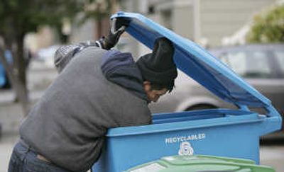 A man picks out items from a recycling container in San Francisco. Strangers rifling through recyclables from neighborhood curbs are cashing in on high prices for aluminum, glass and cardboard. States and municipalities have responded with more stringent laws, big fines and even jail time for large-scale thefts. Associated Press
 (Associated Press / The Spokesman-Review)