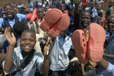 
Children in Malawi hold up donated recycled Crocs shoes during a recent Crocs shoe donation called 