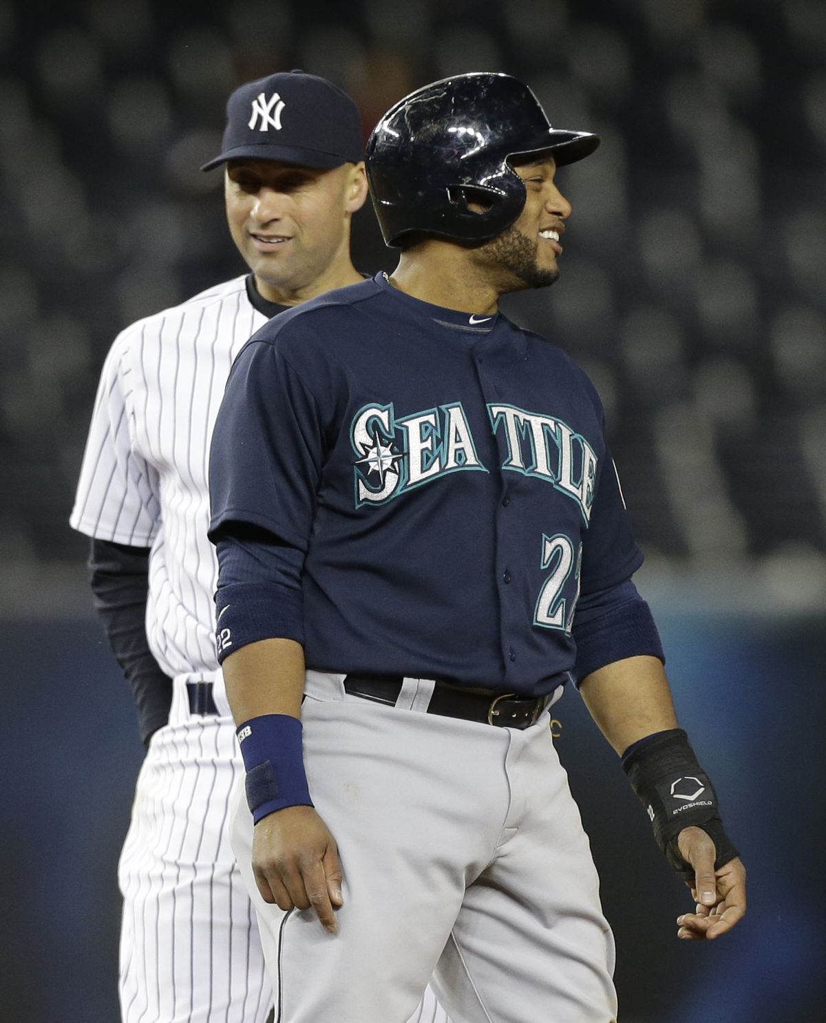 M’s Robinson Cano was greeted by Derek Jeter, left, amid Bronx cheers in his return to Yankee Stadium and left a winner Tuesday. (Associated Press)