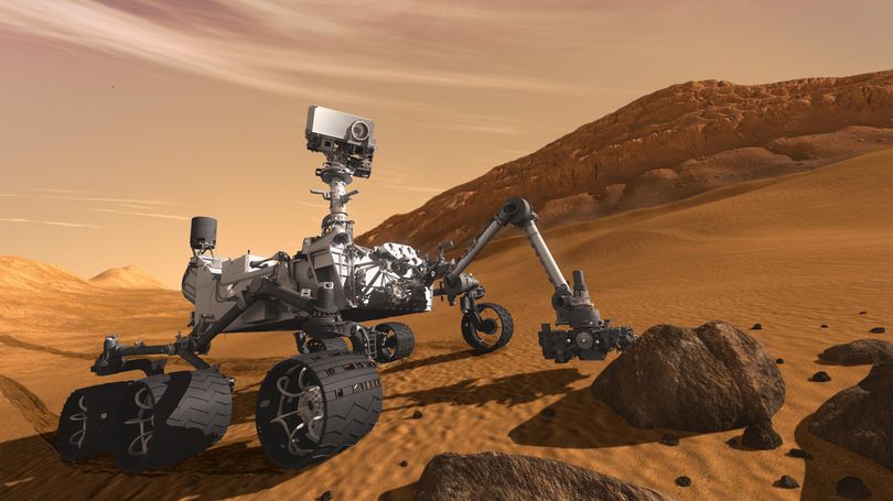 In this 2011 artist’s rendering provided by NASA/JPL-Caltech, the Mars Science Laboratory Curiosity rover examines a rock on Mars with a set of tools at the end of its arm, which extends about 7 feet. (Associated Press)