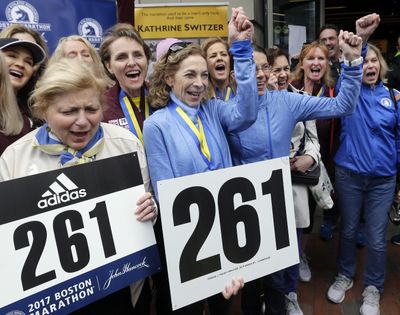 Kathrine Switzer, middle with fist up, the first official woman entrant in the Boston Marathon 50 years ago, cheers at a news conference, Tuesday, April 18, 2017, in Boston, where her bib No. 261 was retired in her honor by the Boston Athletic Association. Switzer is surrounded by runners with her 261 Fearless foundation, and at far left is, BAA President Joann Flaminio. (Elise Amendola / Associated Press)
