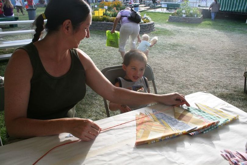 North Idaho Fair attendees make a circus banner out of secondhand sheets at the Down to Earth craft booth in 2009. This year's DTE craft activity will be held on Aug. 25. (Megan Cooley)