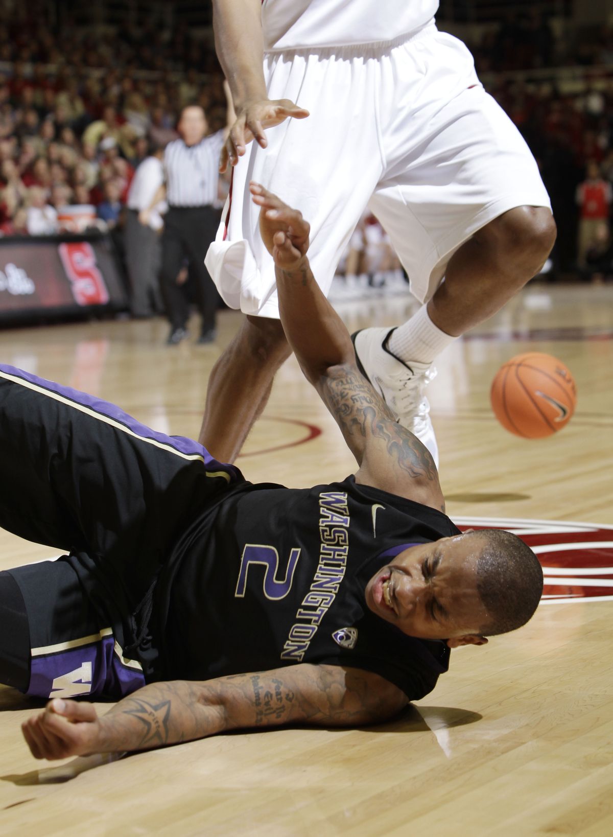 Washington guard Isaiah Thomas (2) is tripped up by Stanford player in the second half of an NCAA college basketball game in Stanford, Calif., Thursday, Jan. 13, 2011. (Paul Sakuma / Associated Press)