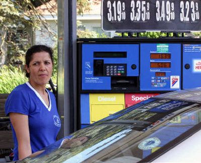 
Sandra Martins of Hyannis, Mass., adds gas to her car at a Mobil station in Falmouth, Mass. New evidence shows that the portion of gas prices tied to refining inflates on its own, apart from the cost of oil. 
 (Associated Press / The Spokesman-Review)
