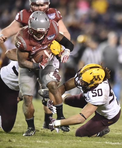 Washington State Cougars running back Jamal Morrow runs the ball against the Minnesota defense during the Holiday Bowl last Dec. 27. The Gophers’ defensive line coach during that game, Jeff Phelps, is now the defensive line coach for Washington State. (Tyler Tjomsland / The Spokesman-Review)