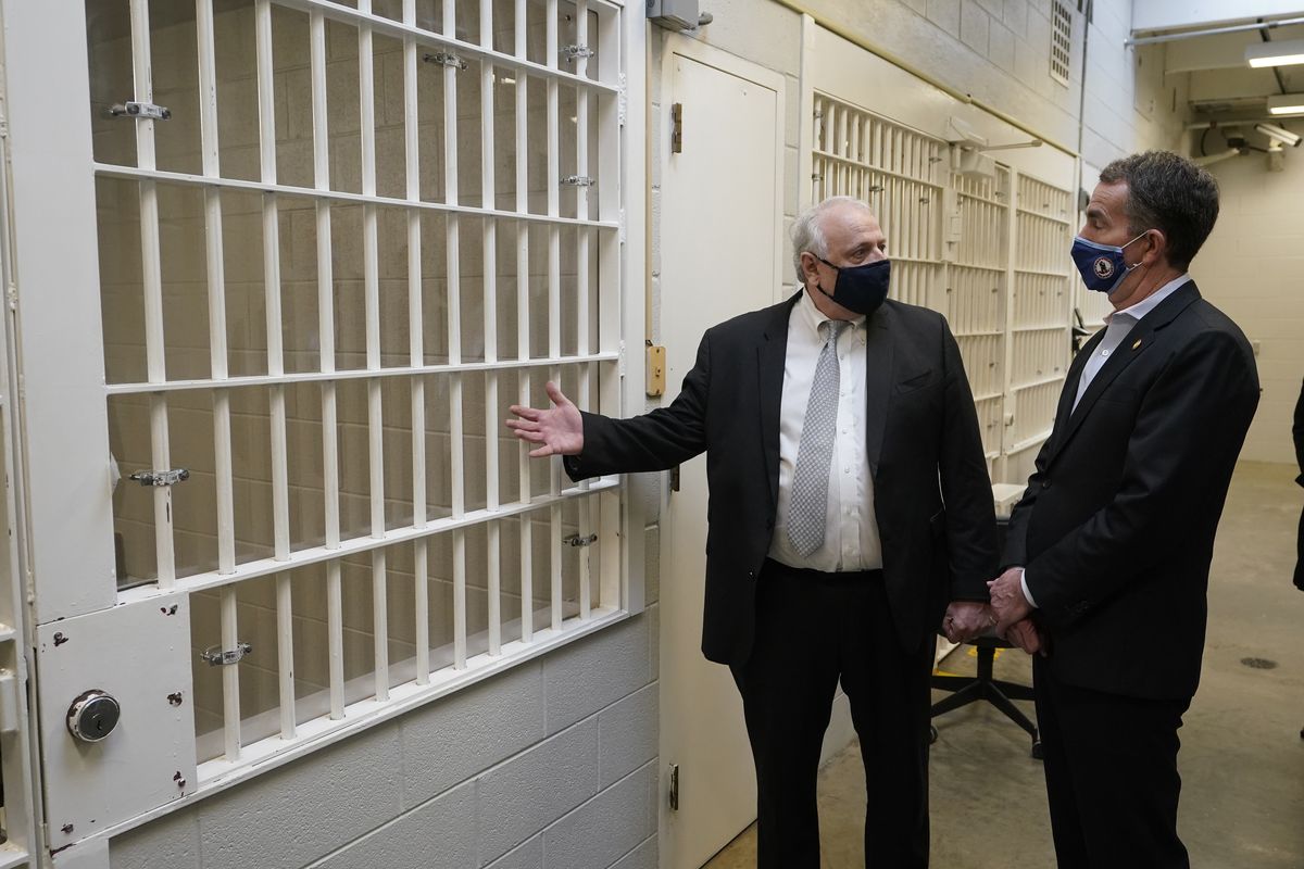 Virginia Gov. Ralph Northam, right, listens to operations director George Hinkle as he explains the workings of the holding cells near the death chamber at Greensville Correctional Center prior to the governor signing a bill abolishing the death penalty, in Jarratt, Va., Wednesday, March 24, 2021.  (Steve Helber)