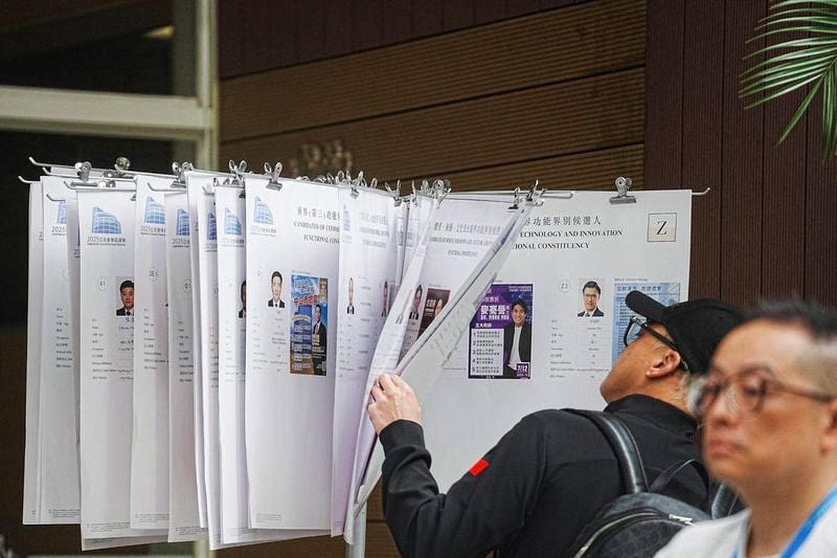 A voter checks on the candidates at a polling station in Tai Po during the Legislative Council general election in Hong Kong, Sunday.   (Reuters )