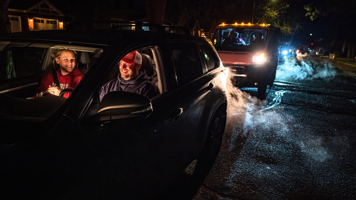 Lauren and Damon Smith, with their daughter Alora, 12, in the back seat, eat some take-out food while they line up on Tekoa Street for the Manito Holiday Light drive-thru event to start in Manito Park, Wednesday, Dec. 15, 2021.  (COLIN MULVANY/THE SPOKESMAN-REVIew)