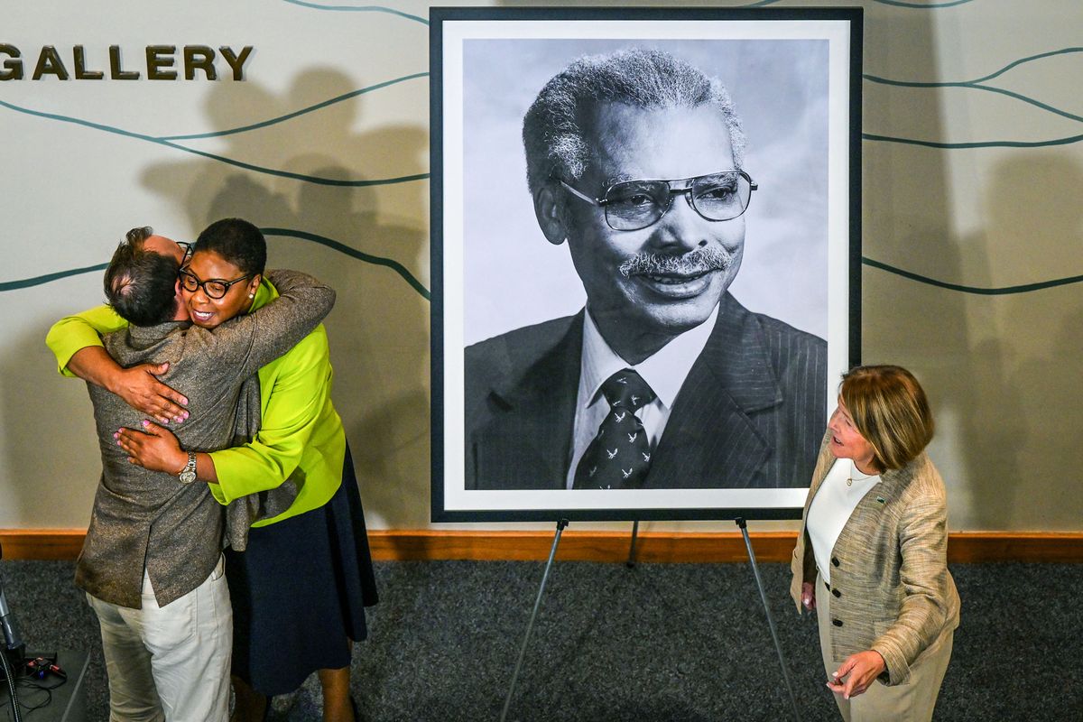 Spokane Arts Executive Director Skyler Oberst, left, is hugged and thanked by Spokane City Council President Betsy Wilkerson after the pair unveiled a portrait of former Spokane Mayor Jim Chase on Wednesday at the Chase Gallery in City Hall. Mayor Lisa Brown is at right.  (Dan Pelle/For The Spokesman-Review)