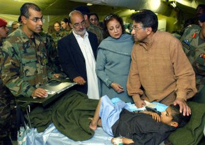 
Pakistani President Gen. Pervez Musharraf, right, and his wife visit a survivor of the Kashmiri earthquake at an Army hospital in Muzaffarabad Friday. 
 (Associated Press / The Spokesman-Review)