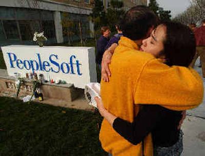 
PeopleSoft employees embrace outside of the company's headquarters in Pleasanton, Calif. on Friday. Oracle Corp. plans to lay off 5,000 employees as a result of its PeopleSoft takeover.
 (Associated Press / The Spokesman-Review)