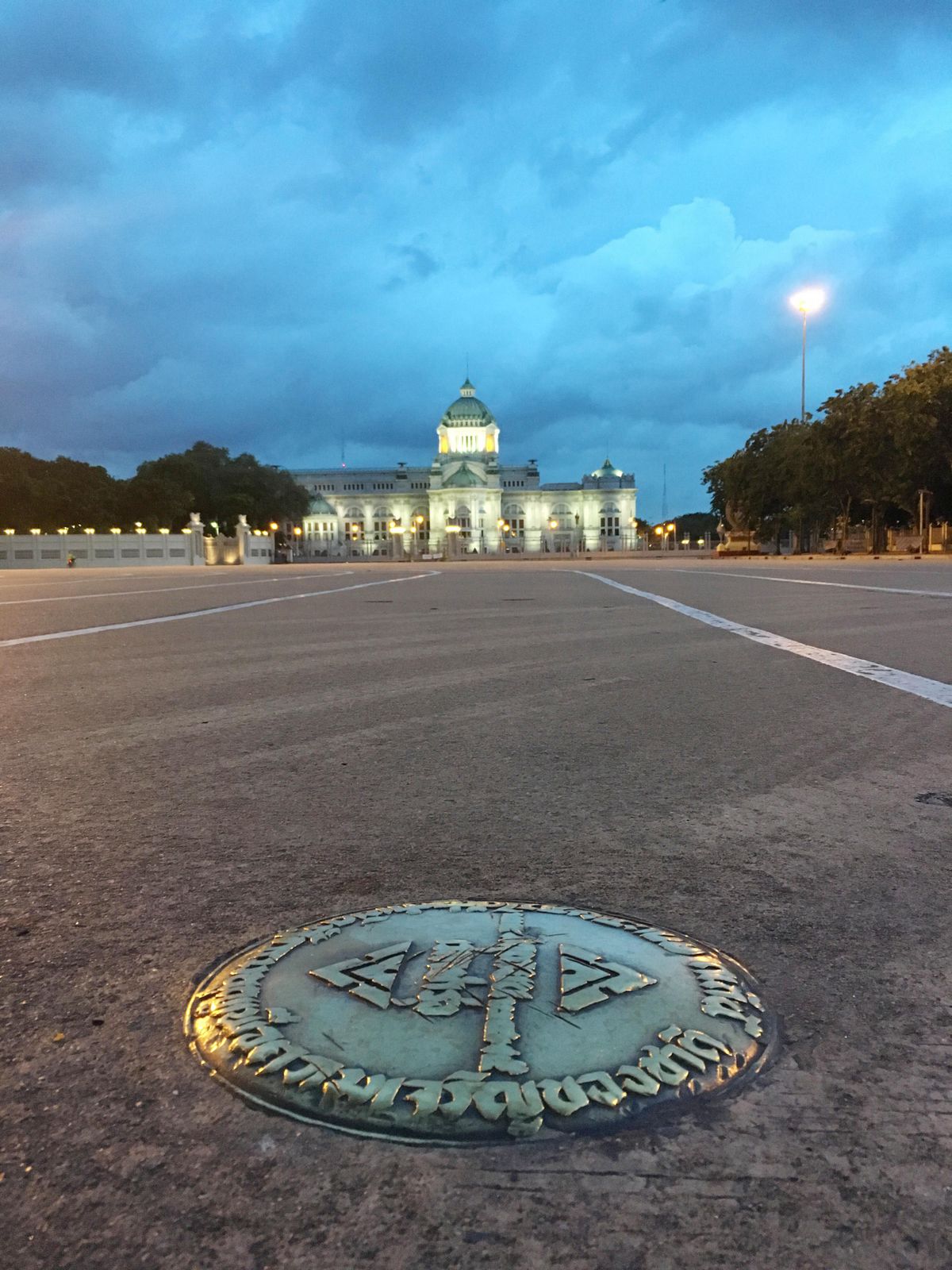 In this Oct. 2, 2016, photo, a small bronze plaque commemorating Thailand’s 1932 revolution rests in the pavement of the Royal Plaza in front of the Ananta Samakhom throne hall in Bangkok, Thailand. In early April, the plaque was mysteriously removed by parties unknown and substituted by one praising the Chakri Dynasty, whose 10th king took the throne last December. A disinclination by the authorities to find those responsible adds another element of mystery. (Apichart Khunnawatbandit / Associated Press)