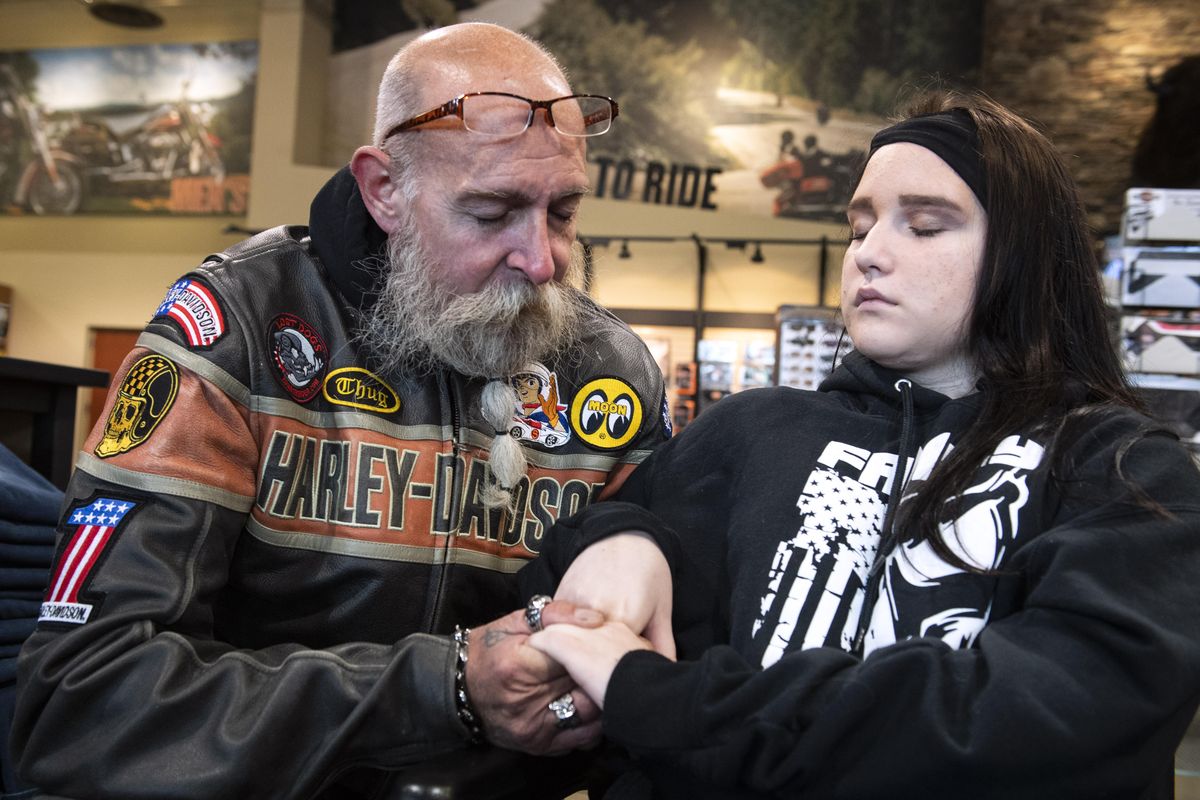Man The Family Up member and organizer Randy Dickerson prays with Savannah Sutton, 14, who is recovering from an April car accident. MTFU held a motorcycle rally fundraiser June 10 to help the Sutton family with medical bills. (Colin Mulvany / The Spokesman-Review)