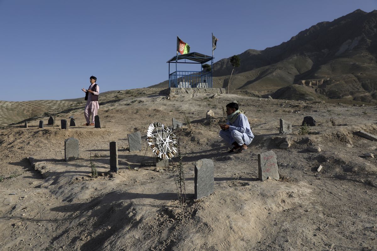 Afghan men prays near the grave of their relatives killed in bombings near Syed Al-Shahada School last month at cemetery on the outskirts of Kabul, Afghanistan, Wednesday, June 2, 2021. After the collapse of the Taliban 20 years ago, Afghanistan
