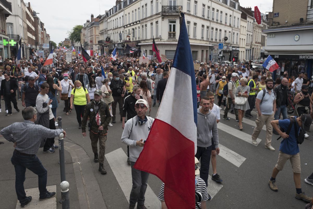 Demonstrators march in Lille, northern France, Saturday, Aug. 21, 2021, during a rally against the COVID-19 health pass needed to access restaurants, long-distance trains and other venues.  (Michel Spingler)