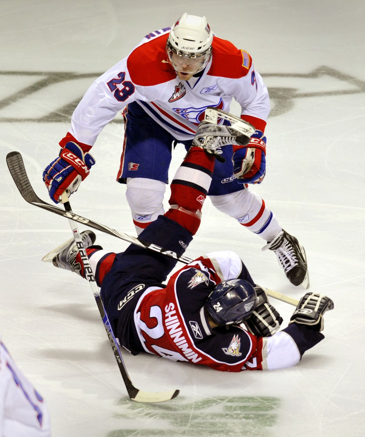 Chasing the puck in the first period, Spokane Chief Corbin Baldwin (23) collides with Tri-City