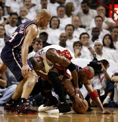 
Miami's Dwyane Wade, center, fights for a loose ball with New Jersey's Richard Jefferson, left, and Vince Carter. 
 (Associated Press / The Spokesman-Review)
