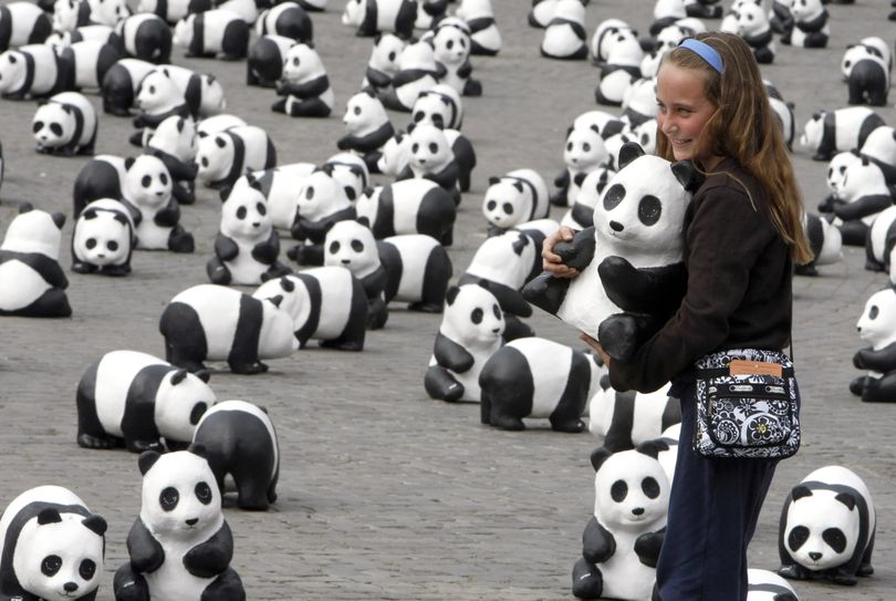 ORG XMIT: XRDL101 A child holds a panda doll in Rome's Piazza del Popolo square, Saturday, April 18, 2009. The World Wide Fund for Nature environmental association placed 1600 paper pulp pandas, symbolizing the last pandas still present in nature, on the square. (AP Photo/Riccardo De Luca) (Riccardo Luca / The Spokesman-Review)