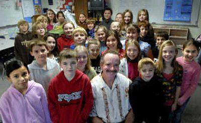 
Skyway Elementary fifth-grade teacher Paul Jones sits for a photo with his class in Coeur d'Alene on Dec. 13. The class adopted a family and purchased gifts for them for Christmas. 
 (Kathy Plonka / The Spokesman-Review)
