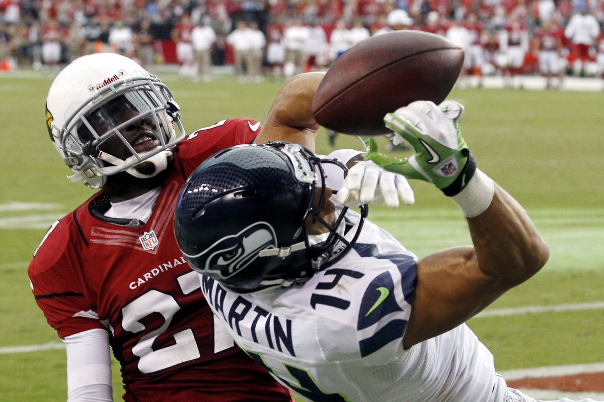 Michael Adams, left, and Cardinals foiled Charly Martin and Seahawks in an opener in Phoenix last Sunday. (Associated Press)