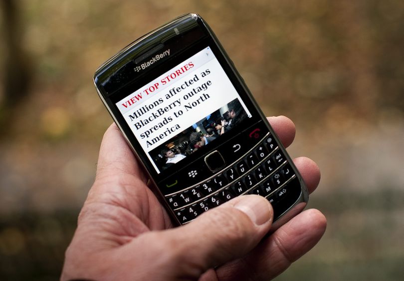 A BlackBerry user reads a story Wednesday about a BlackBerry outage that affected millions of users of the smartphone.