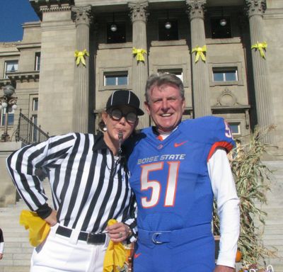 First Lady Lori Otter, left, dressed as a referee, and Gov. Butch Otter, right, dressed as a Boise State football player, host their second annual kids' trick-or-treat on the state Capitol steps on Monday, where they handed out candy and toothbrushes to trick-or-treaters. (courtesy)
