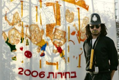 
With graffiti depicting the main contenders of the upcoming Israeli elections as a backdrop, a street performer dressed as a British police officer poses Monday in Rabin Square in downtown Tel Aviv. 
 (Associated Press / The Spokesman-Review)