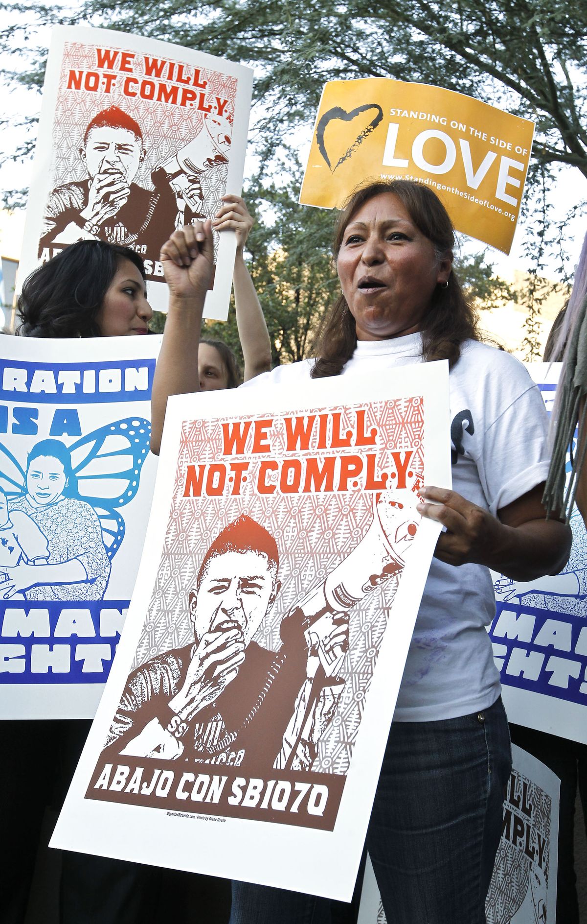 Maria Cruz chants as she joins dozens who rally in front of  U.S. Immigration and Customs Enforcement building, a day after a portion of Arizona