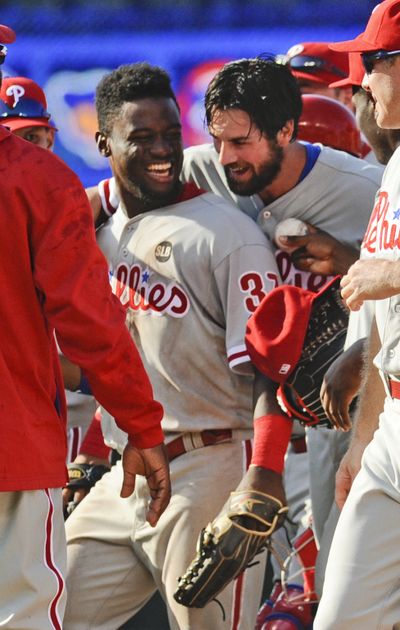 Defensive star Obudel Herrera is hugged by no-hit Phillies pitcher Cole Hamels, right. (Associated Press)
