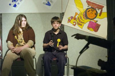 
Josh Taylor gets the signal from Spelling Bee coordinator Kyle Schafter that he has missed his word and must pass the microphone on to the next contestant.  Eleven  students competed for the 2006 crown, including Brianna Clark, left.
 (Christopher Anderson / The Spokesman-Review)