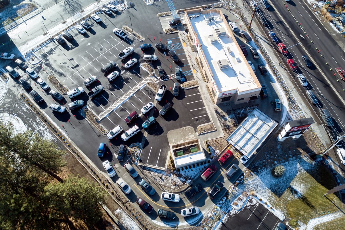 Traffic on the Newport Highway, at right, approaches the new Chick-fil-A fast food restaurant, wraps around the block and weaves through the parking lot in north Spokane on Dec. 1, 2020. It was the first day of the popular chicken sandwich franchise in Spokane.  (Jesse Tinsley/THE SPOKESMAN-REVIEW)