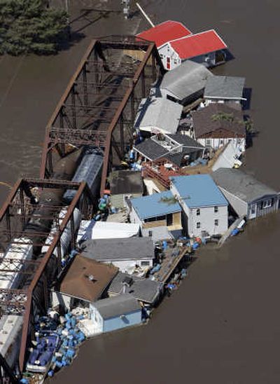 
Buildings and debris are seen floating in the Cedar River against a railroad bridge Saturday in Cedar Rapids, Iowa.  The flooding has forced at least 24,000 people from their homes, officials said. Associated Press
 (Associated Press / The Spokesman-Review)