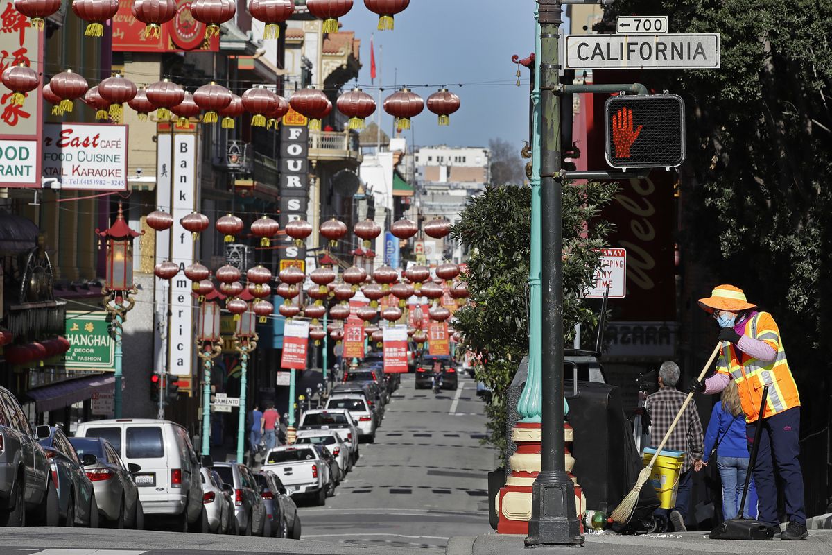 Amasked worker cleans a street Jan. 31, 2020, in the Chinatown district in San Francisco. (Ben Margot)