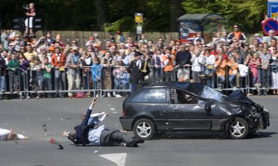 A spectator tumbles to the ground in Apeldoorn, Netherlands, on Thursday after being hit by a car speeding toward a bus carrying Queen Beatrix and her family. Five people were killed.  (Associated Press / The Spokesman-Review)