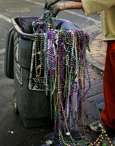 A worker loads Mardi Gras beads into a trash can in front of a Bourbon Street bar in the French Quarter in New Orleans, Wednesday , March 1, 2006, the morning after Mardi Gras, the first since Hurricane Katrina devastated the region. (CAROLYN KASTER / Associated Press)