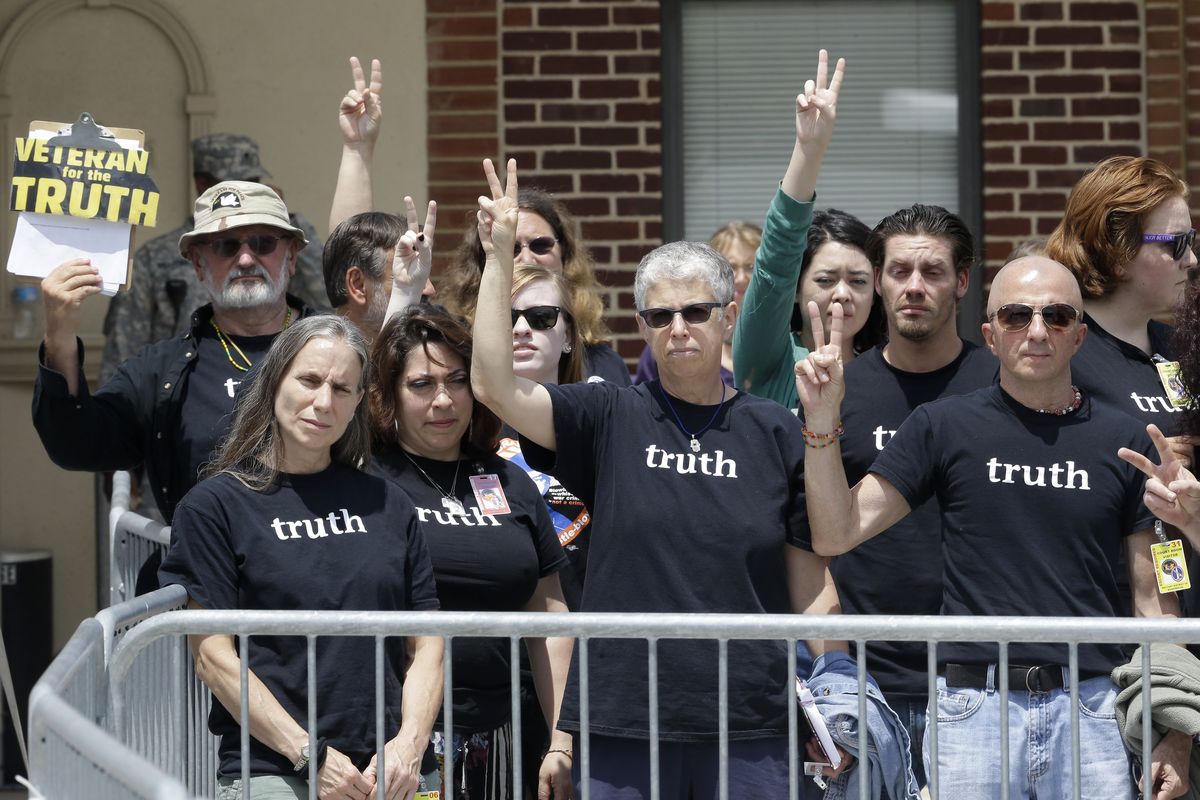 Supporters of Army Pfc. Bradley Manning flash peace signs outside of a courthouse in Fort Meade, Md., on Tuesday after Manning received a verdict in his court martial. (Associated Press)