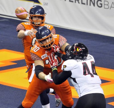 Spokane Shock quarterback Erik Meyer gets off a pass while pressured by Orlando's Mark Robinson and protected by Patrick Afif in game last season at the Spokane Arena.  (Jesse Tinsley)