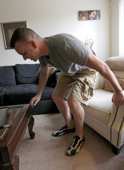 In this Monday, Aug. 20, 2012 photo, Marine Sgt. Ron Strang gets up from a chair in the living room of his home in Jefferson Hills, Pa. just south of Pittsburgh. He lost half of his left thigh muscle in a bomb blast in Afghanistan and with an experimental implant of connective tissue developed from pigs, it has had it strengthened. 