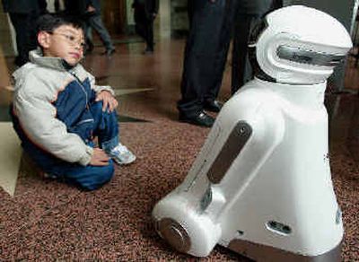 
A child watches the Korean IROBI, an Internet-based family robot, at the U.N.'s annual World Robotics Survey in Geneva's U.N. headquarters, Switzerland, on Wednesday. 
 (Associated Press / The Spokesman-Review)