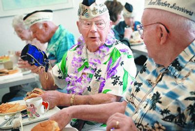 
John Kennedy, center, shows his friend and fellow Pearl Harbor survivor Charles Boyer his camera, which he keeps in a whiskey bag. 
 (Holly Pickett phtos / The Spokesman-Review)